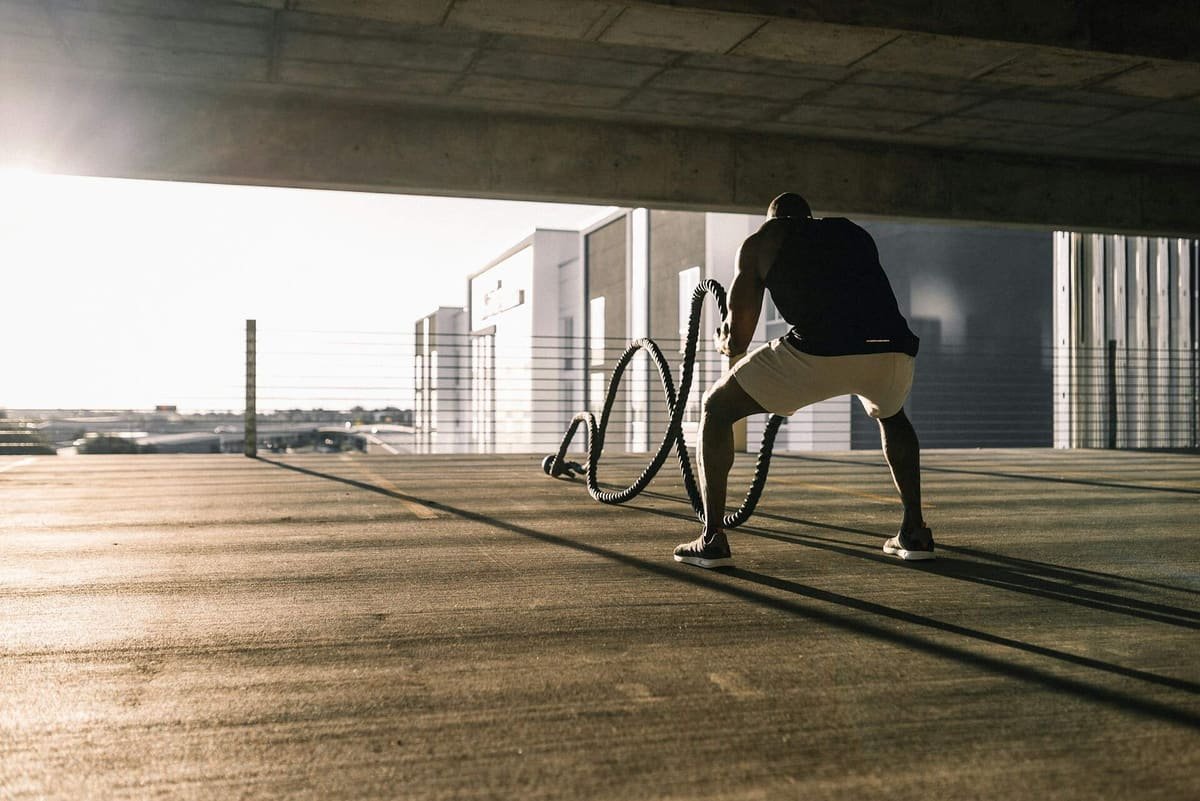 Mann trainiert mit Battle Ropes im Freien