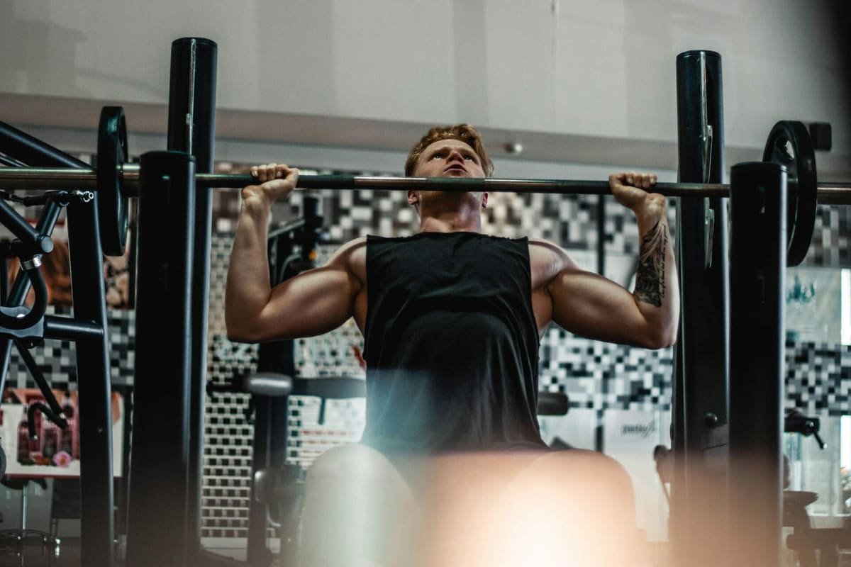 Mann trainiert Latzug an der Maschine im Fitnessstudio
